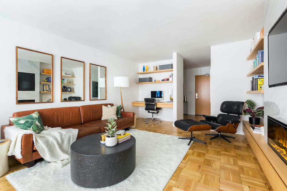 Home office niche with wood shelves and modern desk in mid-century Manhattan living room renovation.