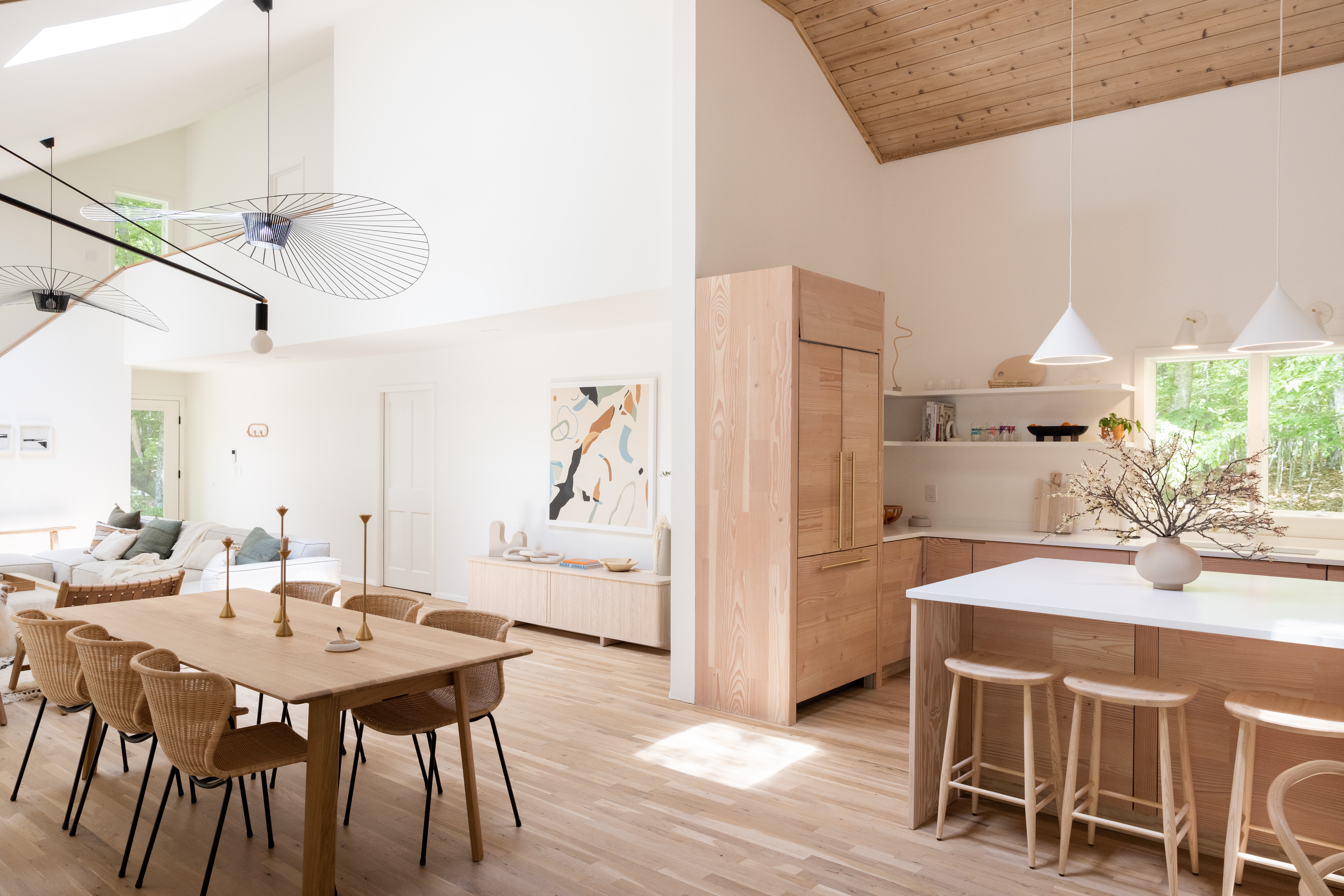 Renovated kitchen in Amagansett, New York featuring wooden cabinetry, wooden dining table set, and island.