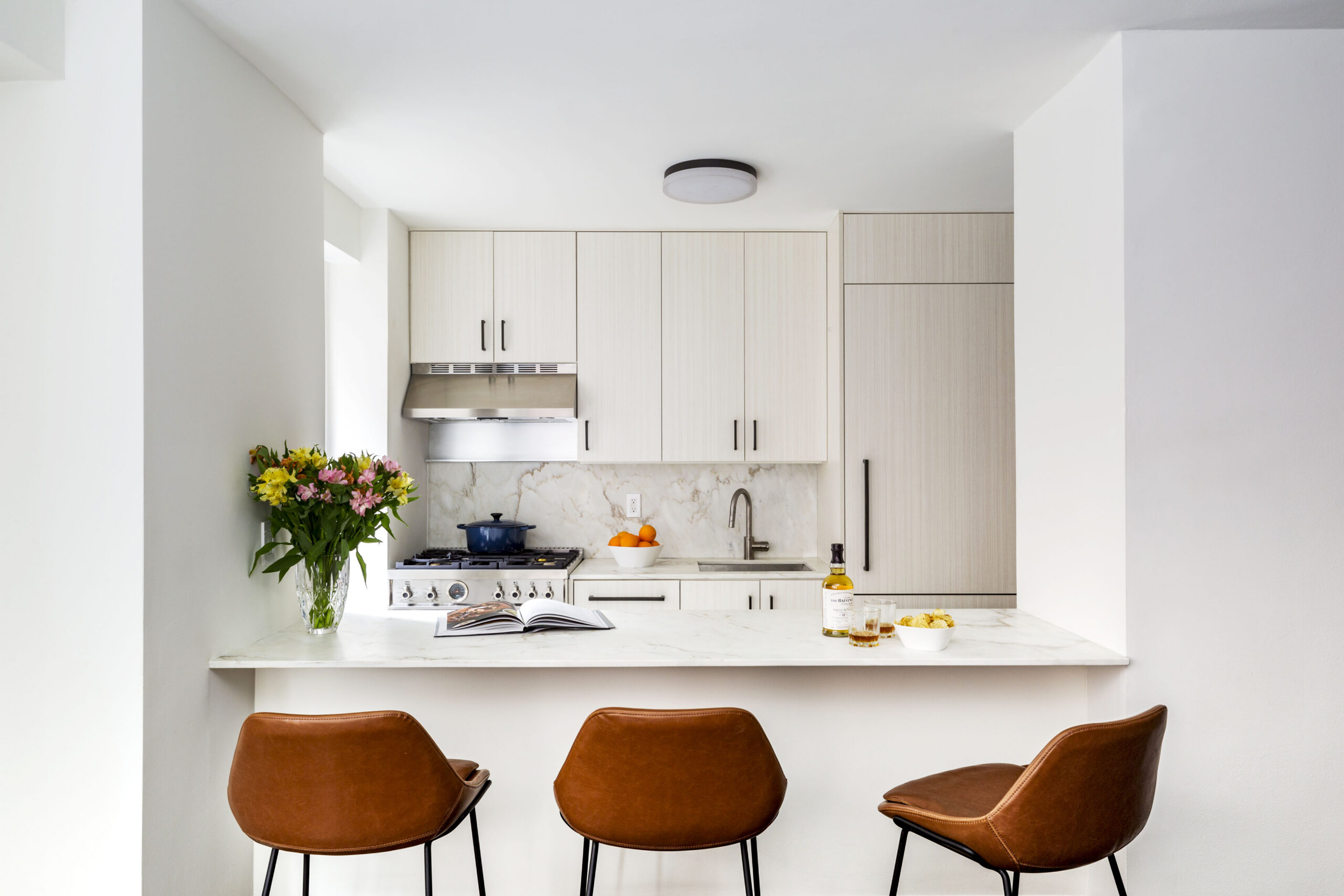 Kitchen peninsula made of Calacatta marble with seating and cabinetry