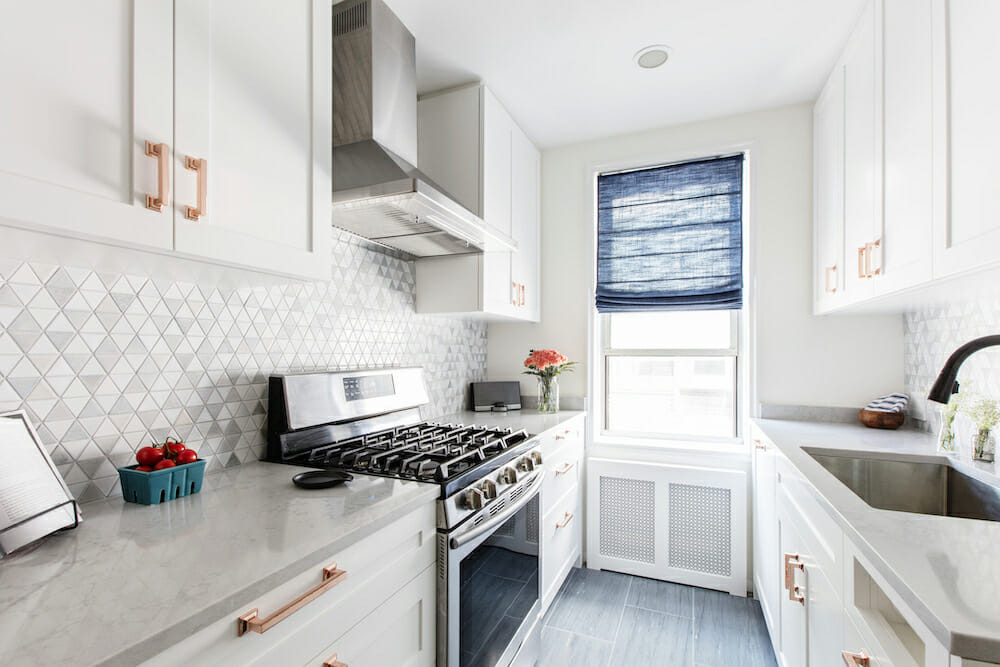 Riverdale co-op Bronx kitchen renovation with stainless range, vent hood, tile backsplash, bright window, modern pulls.